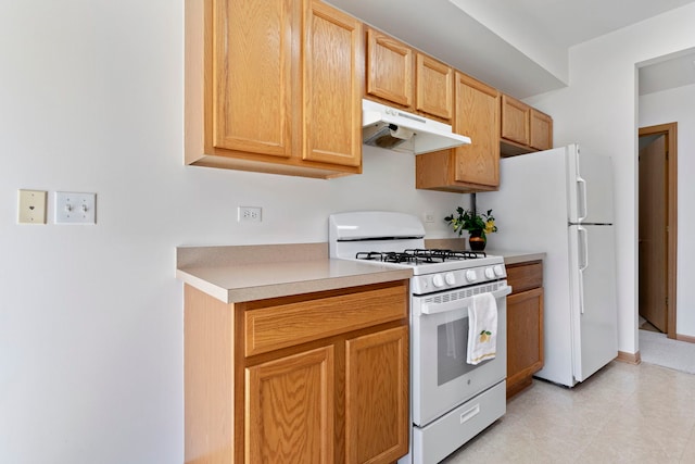 kitchen featuring white appliances, light countertops, and under cabinet range hood