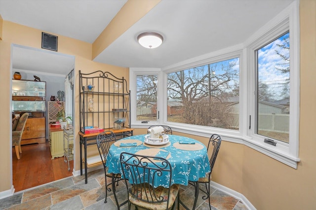 dining space featuring baseboards, stone tile flooring, and ornamental molding