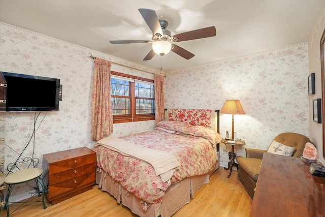 bedroom featuring a ceiling fan, wood finished floors, and wallpapered walls