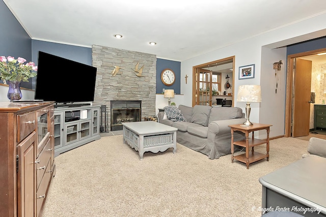 living room with ornamental molding, a stone fireplace, baseboards, and light colored carpet