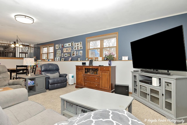 living room featuring a chandelier, ornamental molding, and light colored carpet