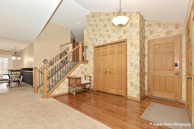 entrance foyer featuring high vaulted ceiling, stairway, wood finished floors, and recessed lighting