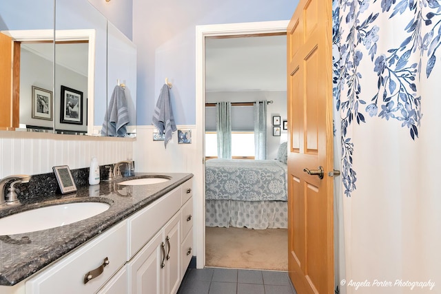 ensuite bathroom featuring tile patterned floors, a sink, ensuite bath, and double vanity