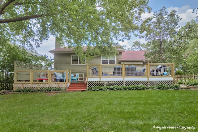 back of house with a yard, a chimney, and a wooden deck