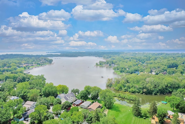 birds eye view of property with a water view and a wooded view