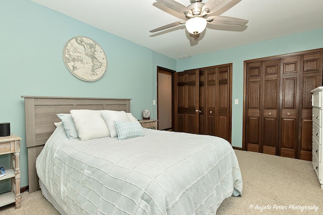 bedroom featuring ceiling fan, baseboards, carpet flooring, and multiple closets