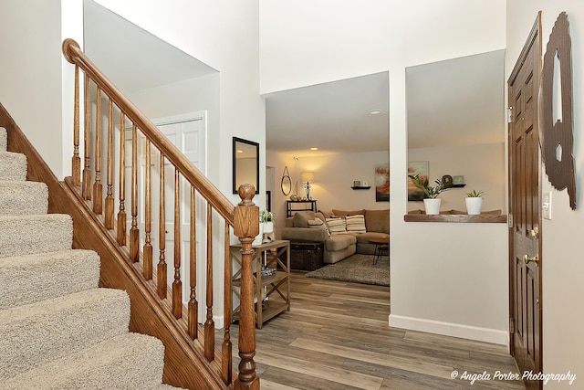 entrance foyer featuring stairway, a high ceiling, and wood finished floors