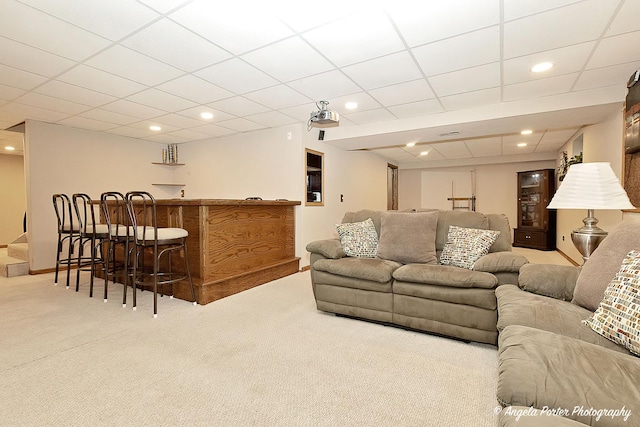 carpeted living room featuring a dry bar, a paneled ceiling, and recessed lighting