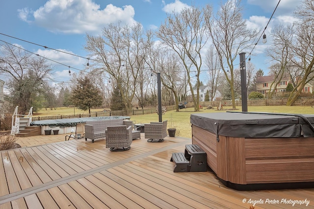 deck with a fenced backyard, a lawn, and a hot tub