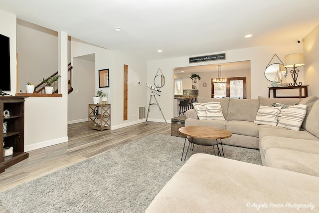 living area featuring visible vents, baseboards, wood finished floors, and recessed lighting