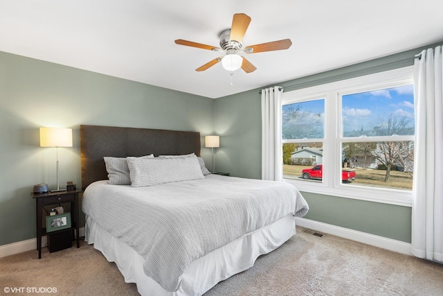 carpeted bedroom featuring visible vents, baseboards, and ceiling fan