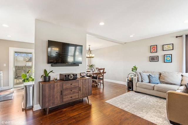 living room with an inviting chandelier, recessed lighting, baseboards, and dark wood-style flooring