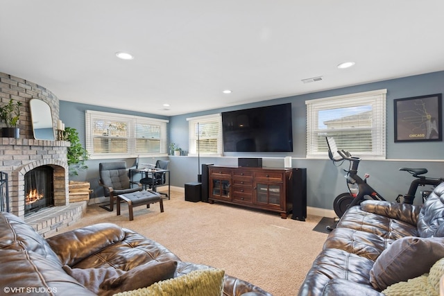 living room featuring visible vents, baseboards, a brick fireplace, and carpet flooring