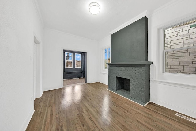 unfurnished living room featuring crown molding, visible vents, and a fireplace