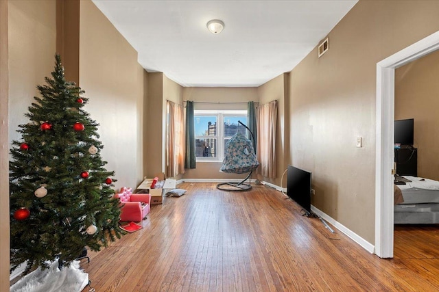 sitting room featuring baseboards, visible vents, and hardwood / wood-style floors