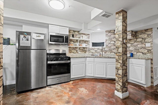 kitchen with finished concrete flooring, visible vents, light stone countertops, stainless steel appliances, and white cabinetry