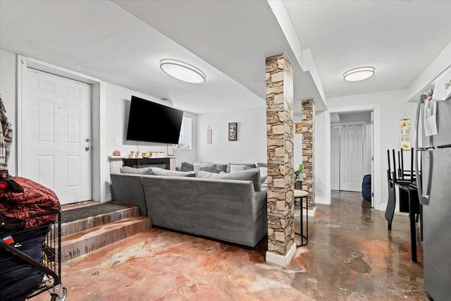 living area with concrete floors and ornate columns