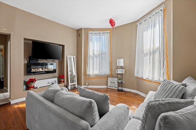 living room with baseboards, plenty of natural light, and hardwood / wood-style floors