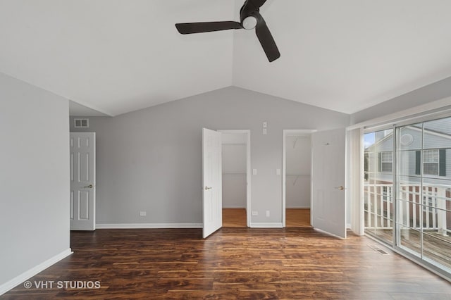 interior space featuring visible vents, wood finished floors, baseboards, and vaulted ceiling