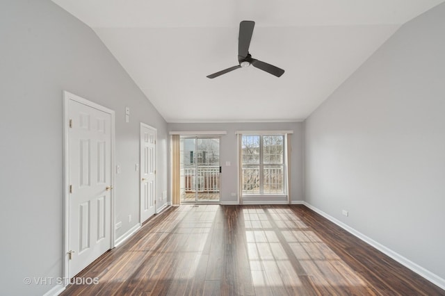 empty room featuring baseboards, lofted ceiling, and dark wood-style flooring