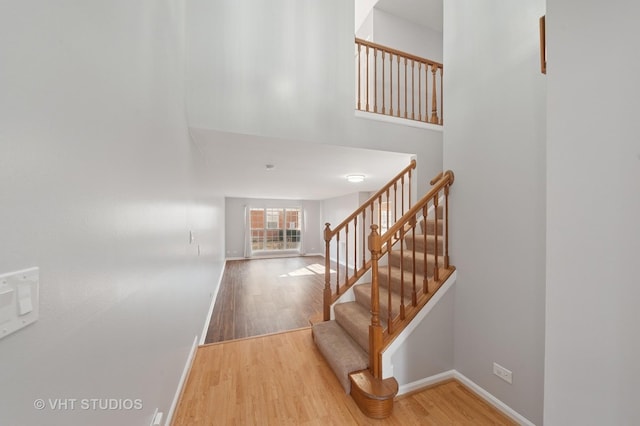 stairs featuring wood finished floors and baseboards