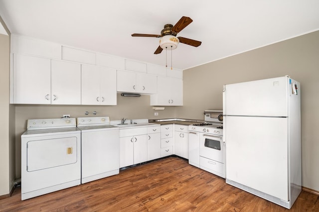 kitchen featuring separate washer and dryer, white appliances, wood finished floors, and white cabinetry