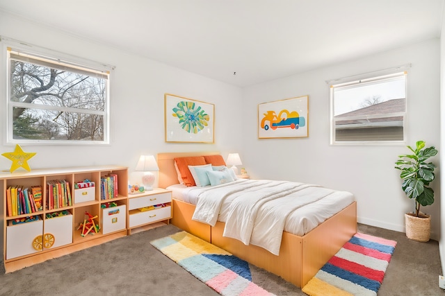 carpeted bedroom featuring multiple windows and baseboards