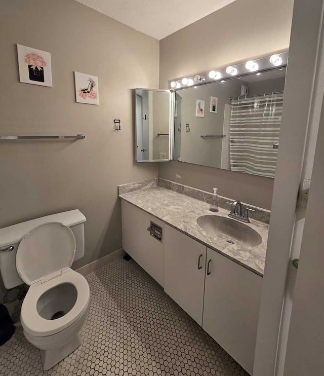 full bath with baseboards, toilet, vanity, and tile patterned flooring