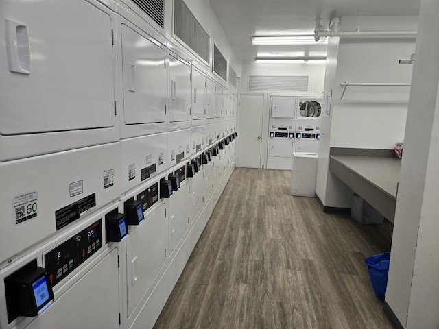 interior space featuring washer and dryer, wood finished floors, and stacked washer and dryer