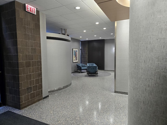 hall featuring recessed lighting, speckled floor, and a paneled ceiling