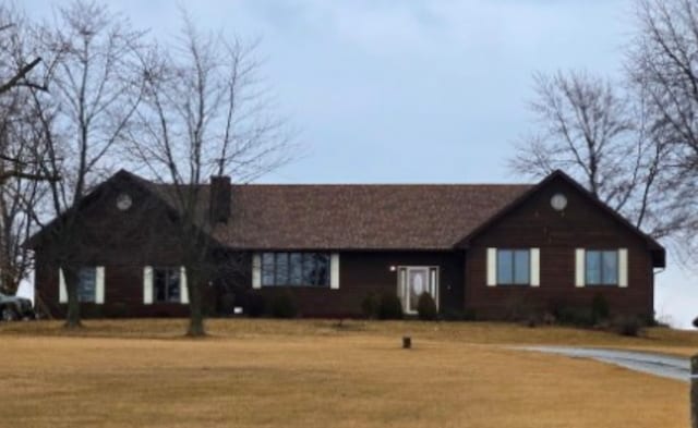 ranch-style home featuring a chimney and a front yard