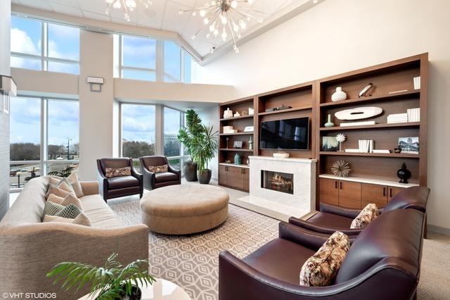 living room featuring a chandelier, high vaulted ceiling, a premium fireplace, and a healthy amount of sunlight