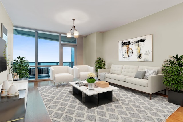 living room with a chandelier, a wall of windows, and wood finished floors