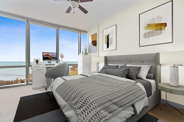 bedroom with light carpet, expansive windows, and a ceiling fan