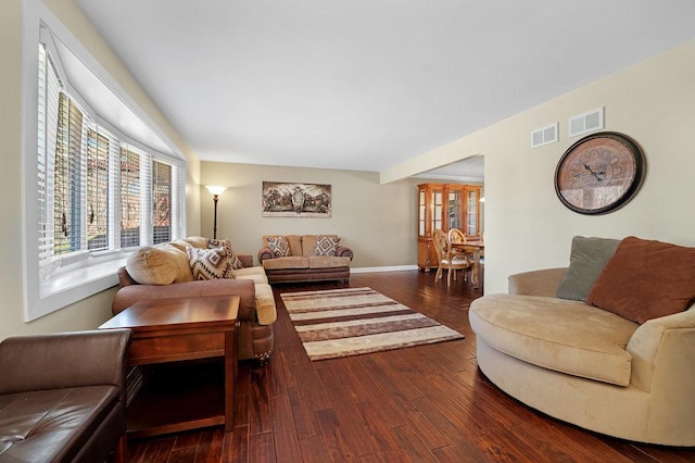 living area featuring baseboards, visible vents, and dark wood-type flooring