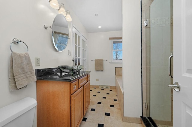 full bathroom featuring a shower stall, toilet, and vanity