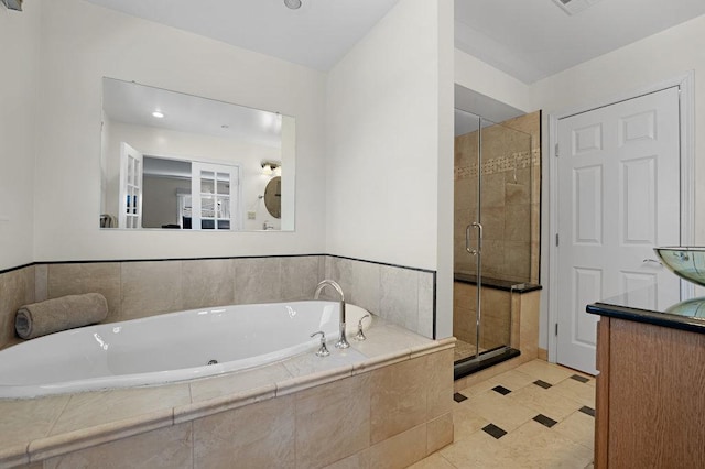 full bathroom featuring a garden tub, a shower stall, and vanity