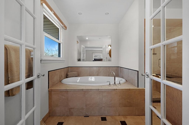 full bathroom featuring a bath and tile patterned floors