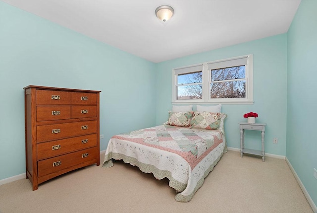 bedroom featuring light colored carpet and baseboards