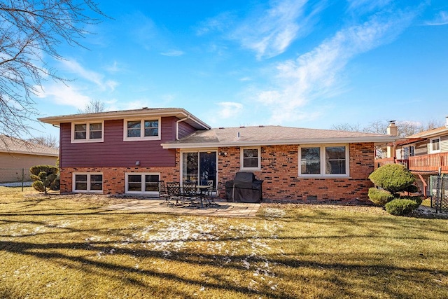 rear view of house featuring a yard, a patio area, and brick siding