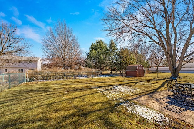 view of yard featuring a storage shed, a patio area, an outdoor structure, and fence