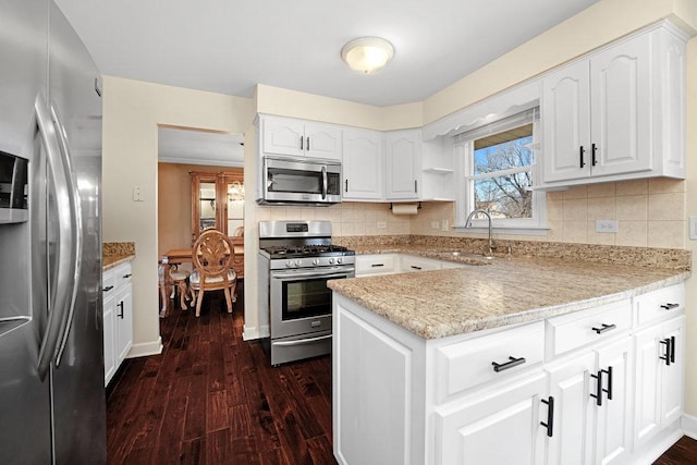 kitchen featuring stainless steel appliances, dark wood finished floors, a sink, and decorative backsplash