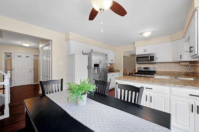 dining room featuring dark wood-type flooring, stairway, and a ceiling fan