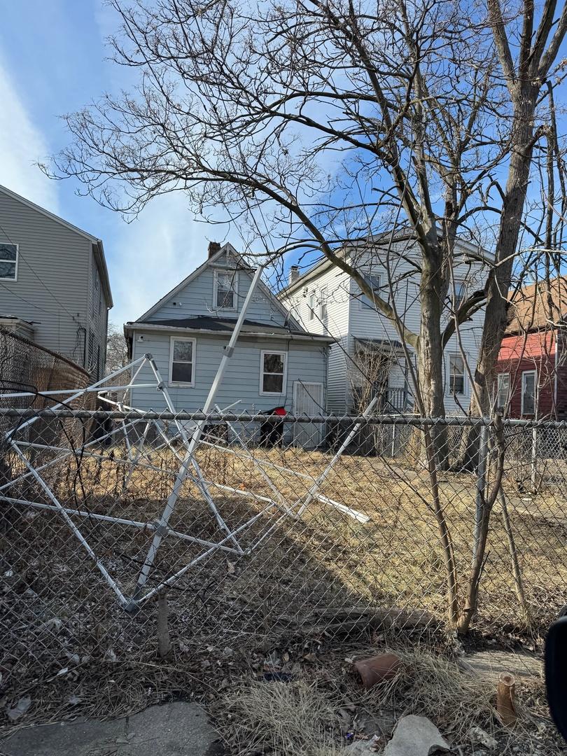 rear view of property featuring fence