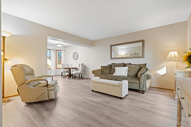 living area featuring light wood finished floors and baseboards