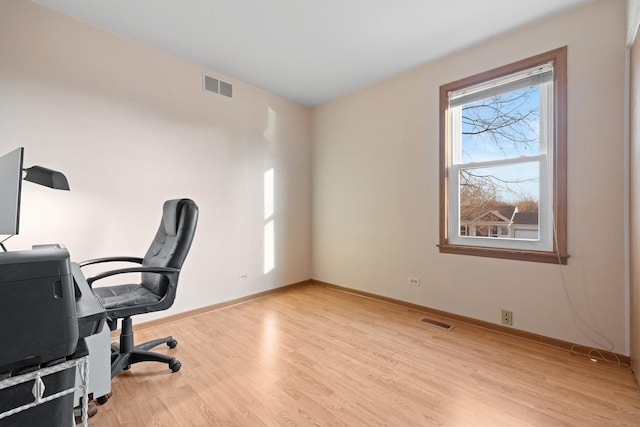 office space featuring visible vents, baseboards, and wood finished floors