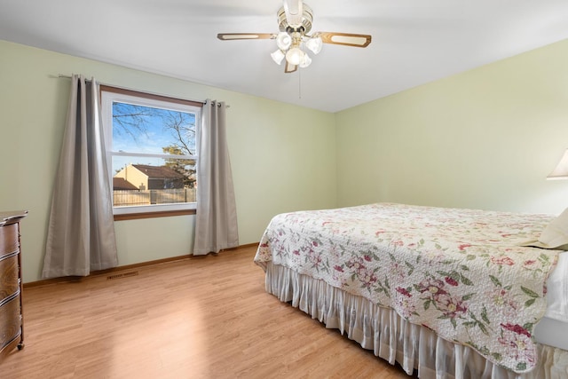 bedroom with visible vents, ceiling fan, light wood-style flooring, and baseboards