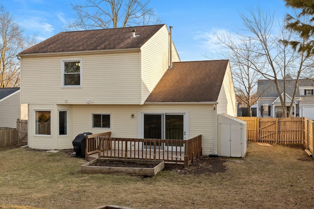 rear view of house featuring a fenced backyard, an outdoor structure, a yard, roof with shingles, and a storage unit