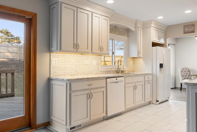 kitchen featuring marble finish floor, tasteful backsplash, visible vents, a sink, and white appliances