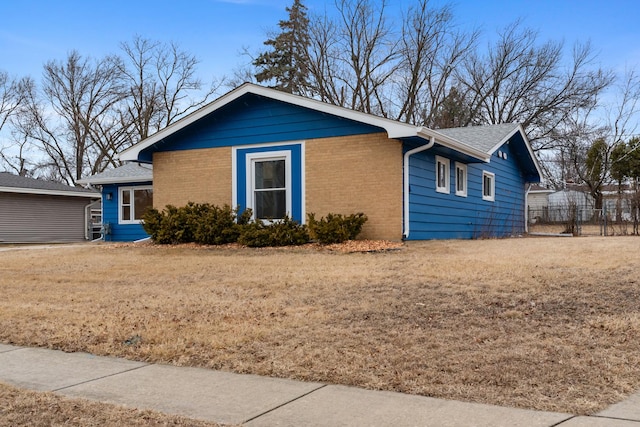 view of front of house featuring a front yard, fence, and brick siding